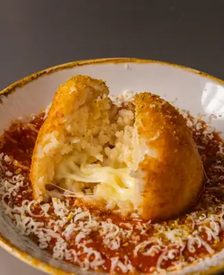 Golden, crisp and built around a molten mozzarella centre. This oversized arancini recipe uses Arla Pro Large Diced Mozz...