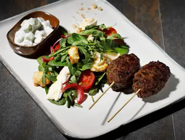 Burgerin parhaat palat herkullisena salaattina – mausteiset pihvit, rapeat krutongit ja raikas tzatziki yhdessä annoksessa.